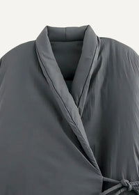 A sleek dark gray quilted kimono style coat with a structured collar and matching tie belt