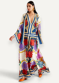 A flowing off-white kimono style maxi dress with bold red purple blue floral and geometric patterns and gold accents