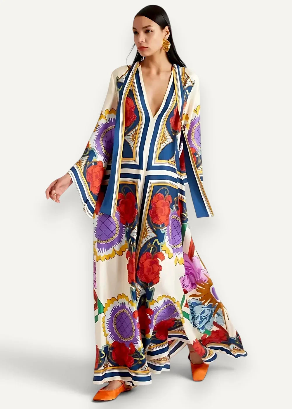 A flowing off-white kimono style maxi dress with bold red purple blue floral and geometric patterns and gold accents