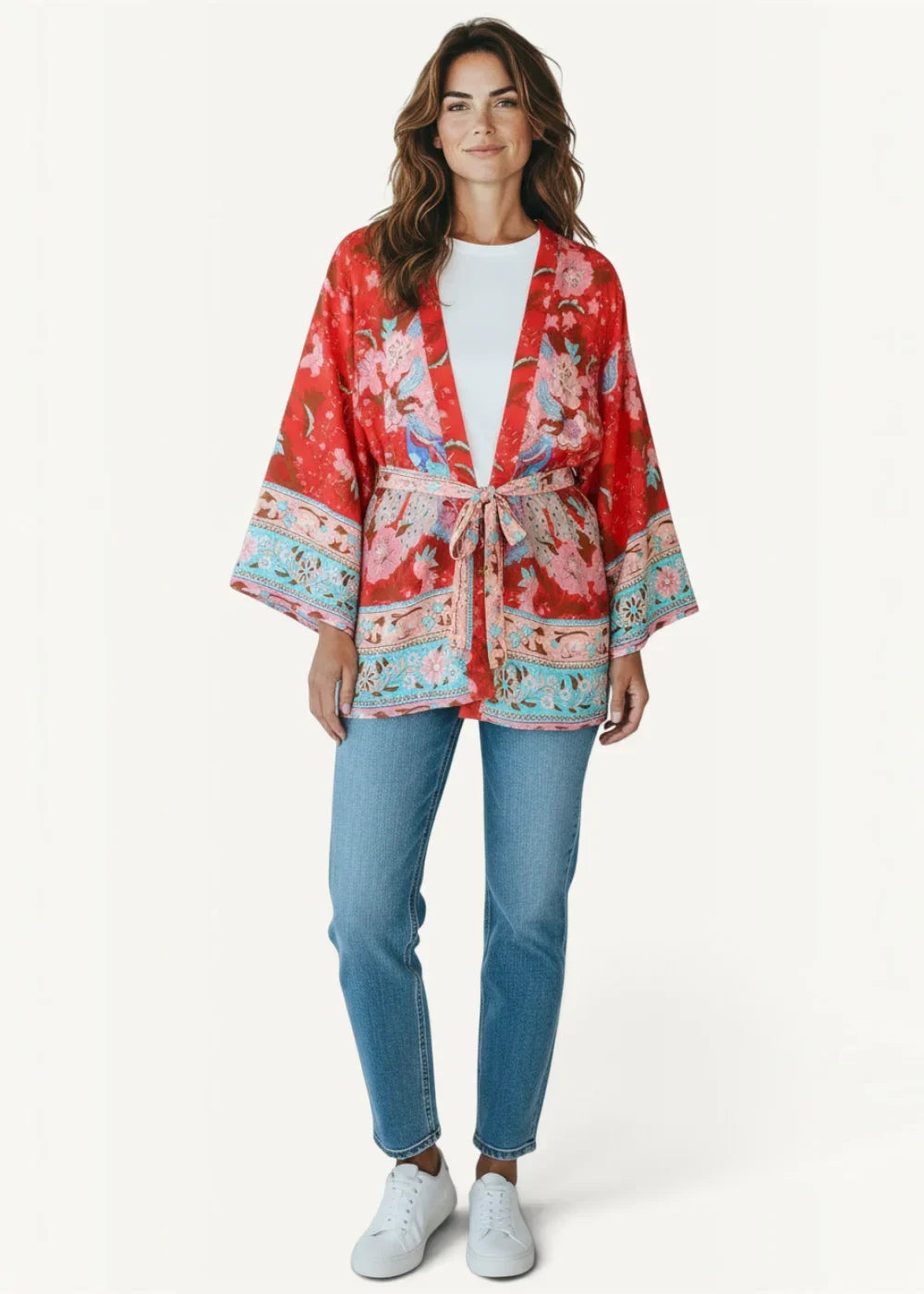 A vibrant red kimono style dress short with intricate pink and turquoise floral patterns and a belted waist