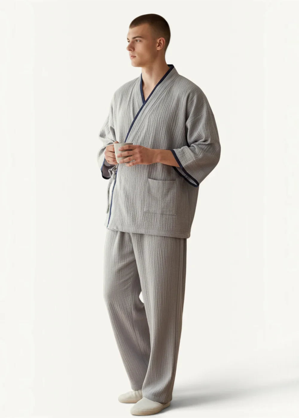 Man wearing the gray kimono style pajama set with navy blue trim for lounging and sleep