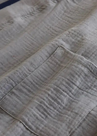 Close-up of the gray kimono style pajama set top with a soft textured weave and stitched patch pocket