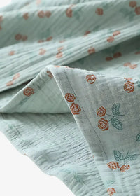 Light blue gauze kimono style pajamas with rust-colored rose and green leaf pattern on soft fabric