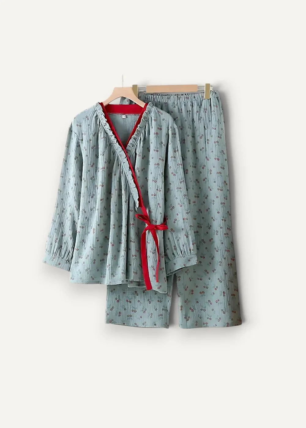 Light blue kimono style pajamas with subtle floral pattern v neck top tied with red ribbon and matching shorts