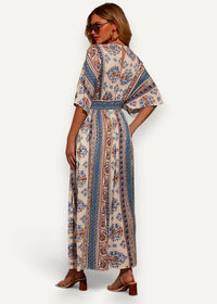 A flowing off-white kimono summer dress with intricate blue and rust floral patterns along vertical stripes
