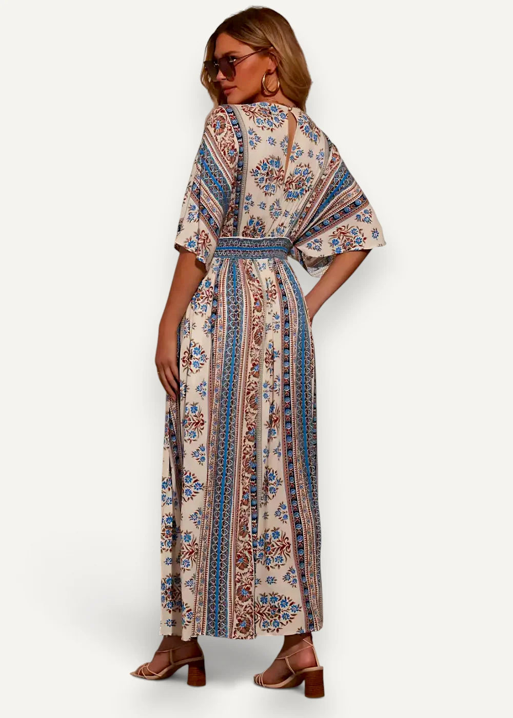 A flowing off-white kimono summer dress with intricate blue and rust floral patterns along vertical stripes
