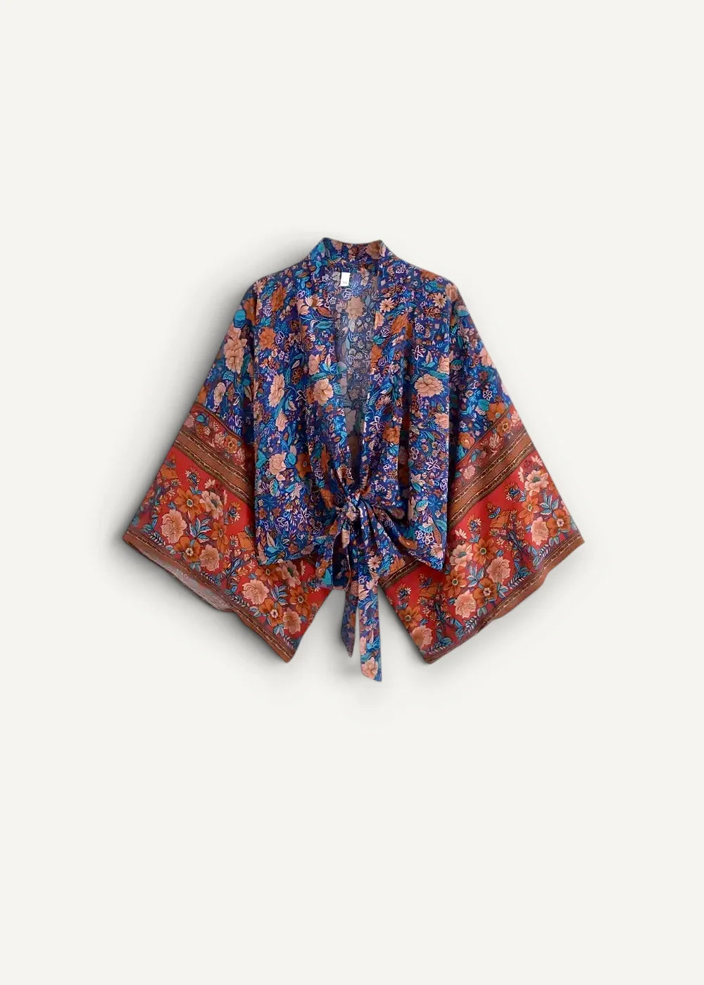 A vibrant floral-patterned kimono top in deep blues and rich reds with a tied front closure