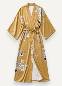 Long gold satin robe with a delicate white and black floral bird pattern and matching belt tied at the waist