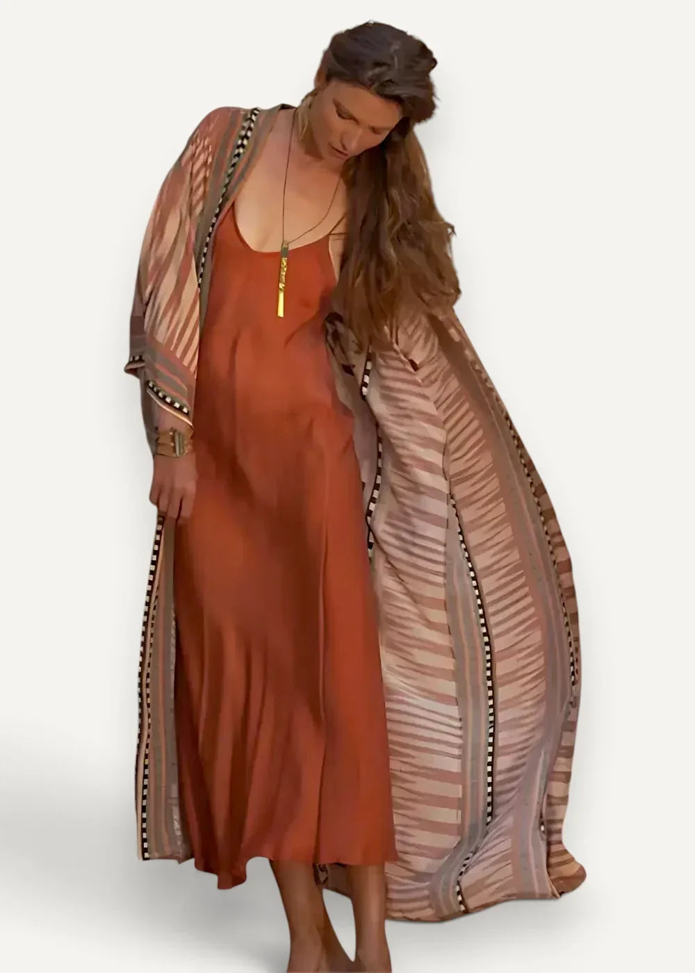 Long kimono dress featuring a rust-orange satin slip dress with a beige and brown striped kimono and beaded trim