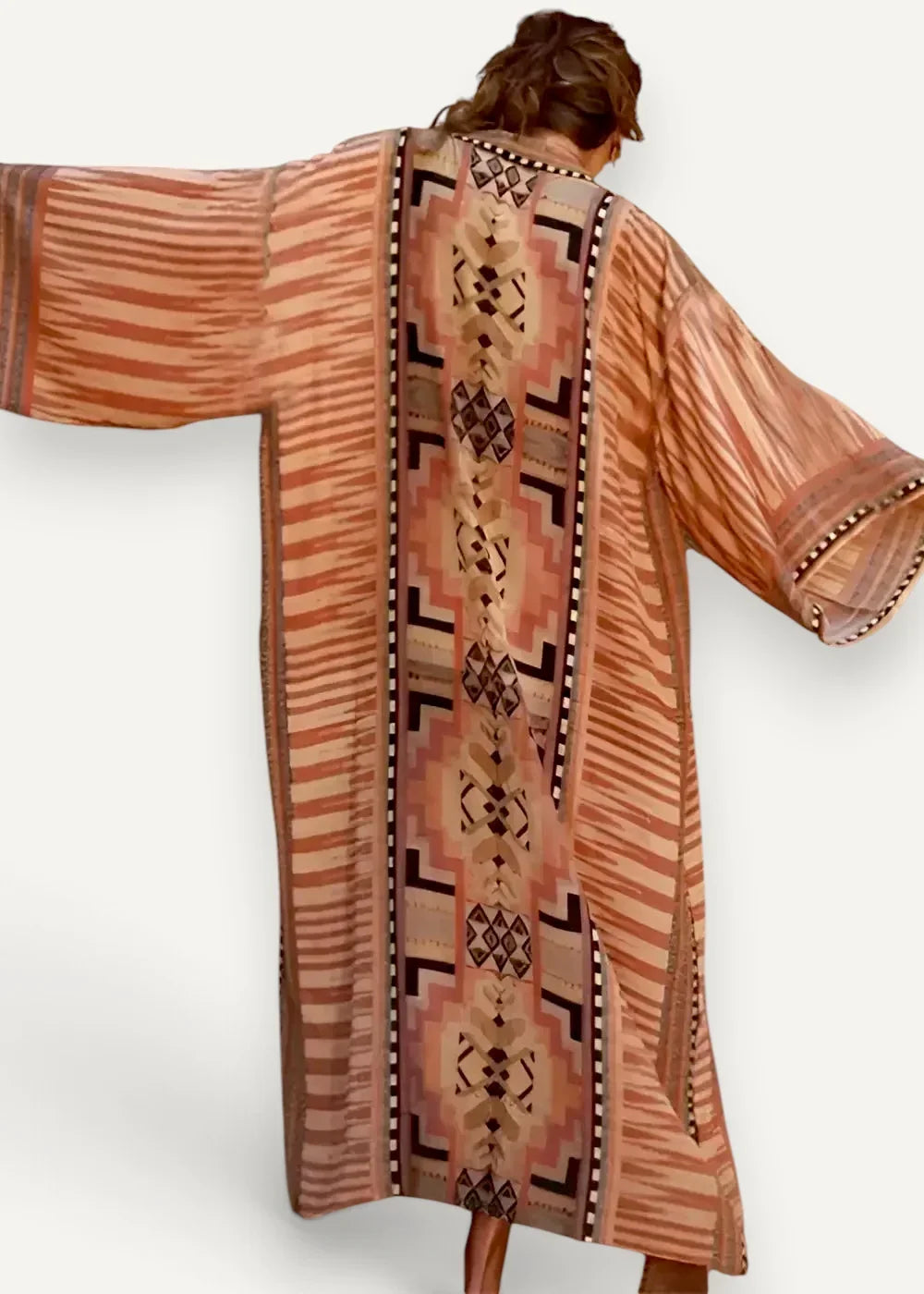 Long kimono dress back showing flowing terracotta and beige kaftan with bold black geometric pattern
