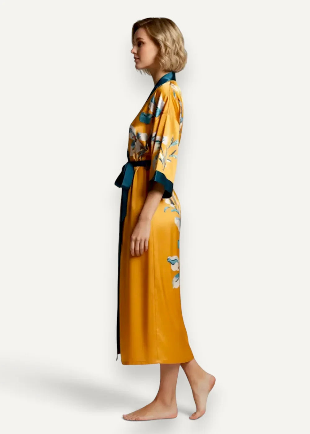 Long satin kimono robe in flowing golden yellow silk with teal floral pattern and matching belt visible from front
