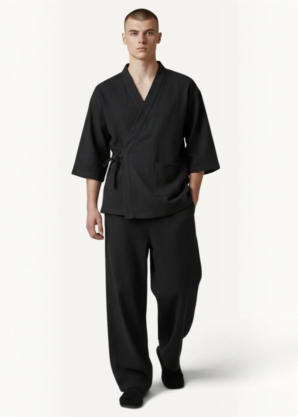 Man wearing black cotton men's kimono pajamas with three quarter sleeves and a tied waist