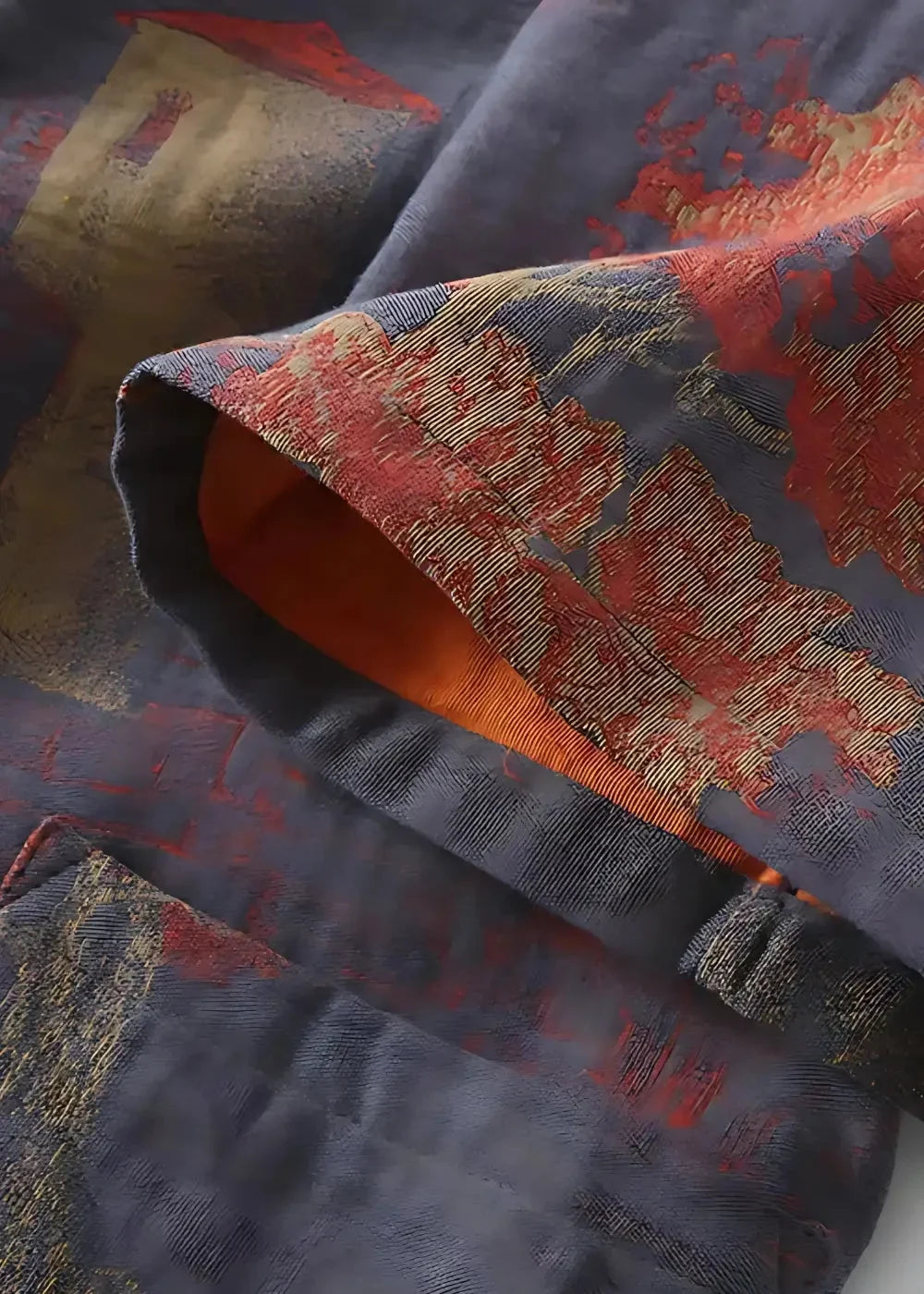 Men’s silk dressing robe in dark blue with intricate red and gold embroidery and visible orange inner lining