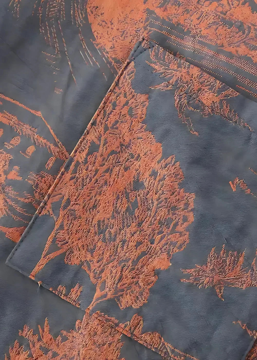 Men’s silk kimono featuring dark blue fabric with intricate orange tree and landscape patterns and a subtle textured weave