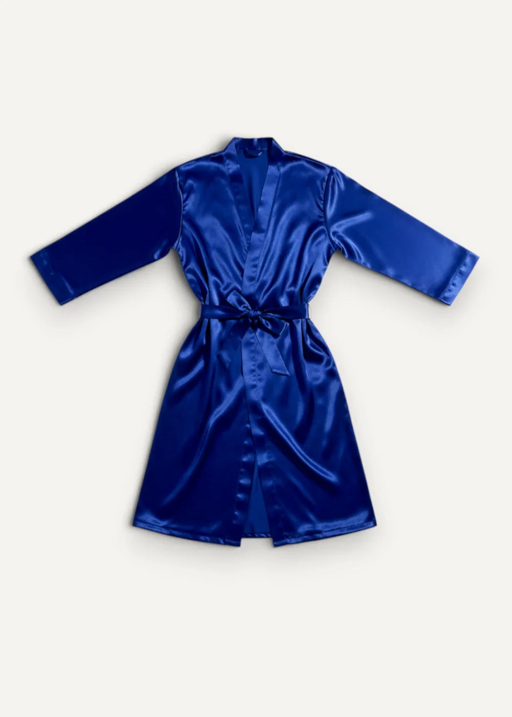 A royal blue men’s silk robe made of satin with a matching belt tied at the waist