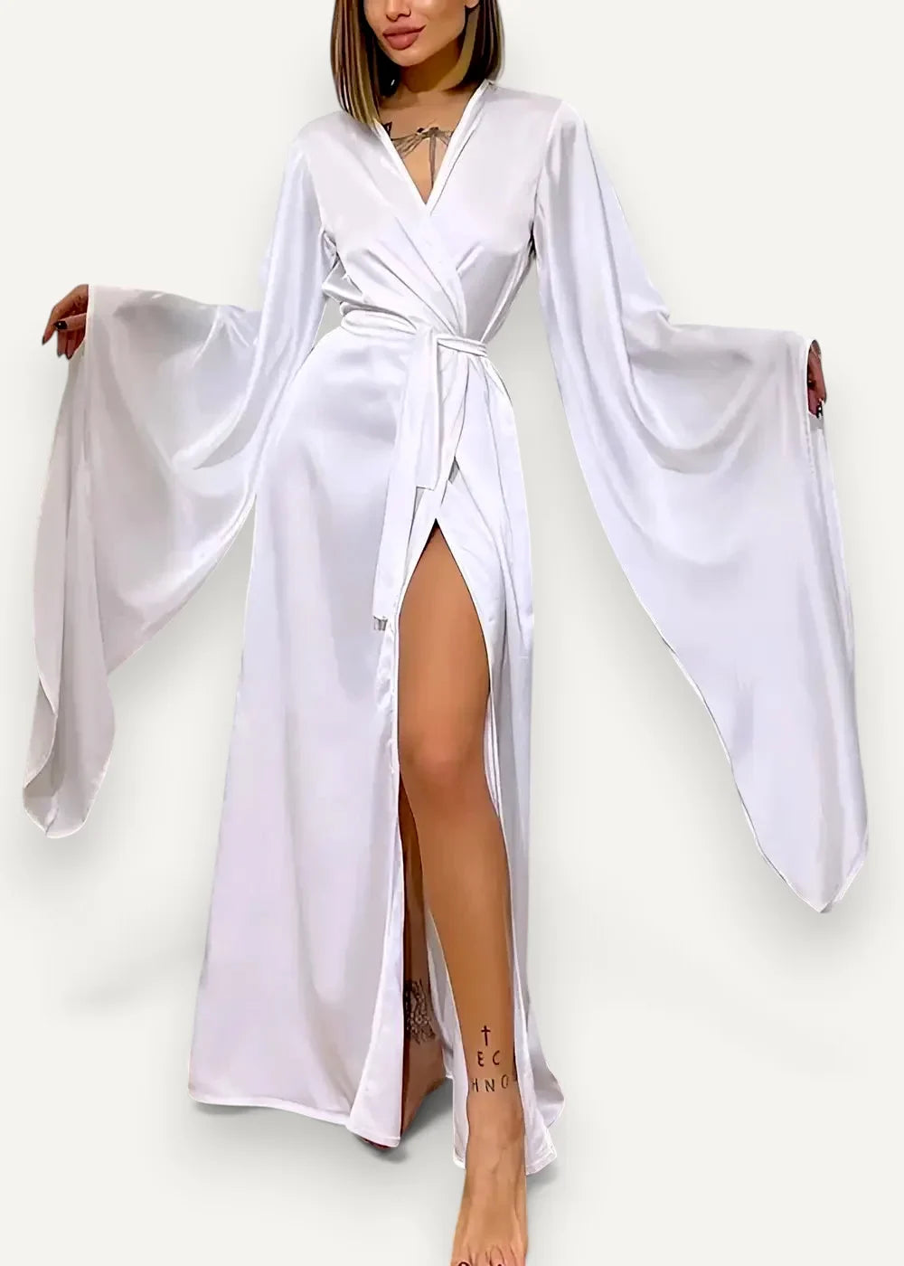 White satin modern kimono dress with wide flowing sleeves and a high slit showcasing elegant design