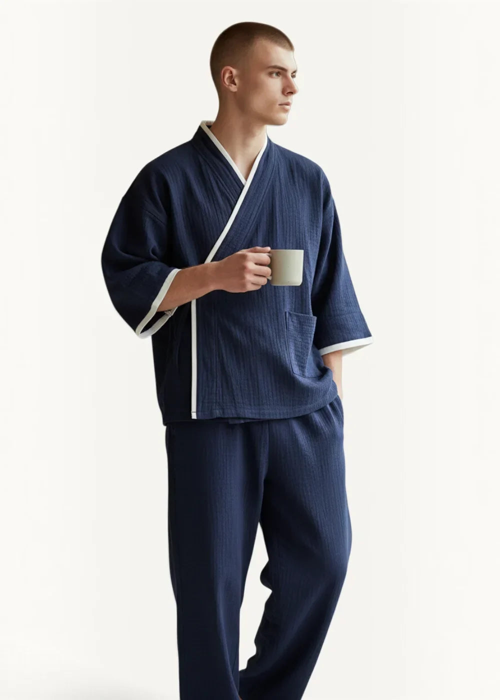 Man wearing navy Japanese kimono pajamas with white trim and a traditional kimono style top