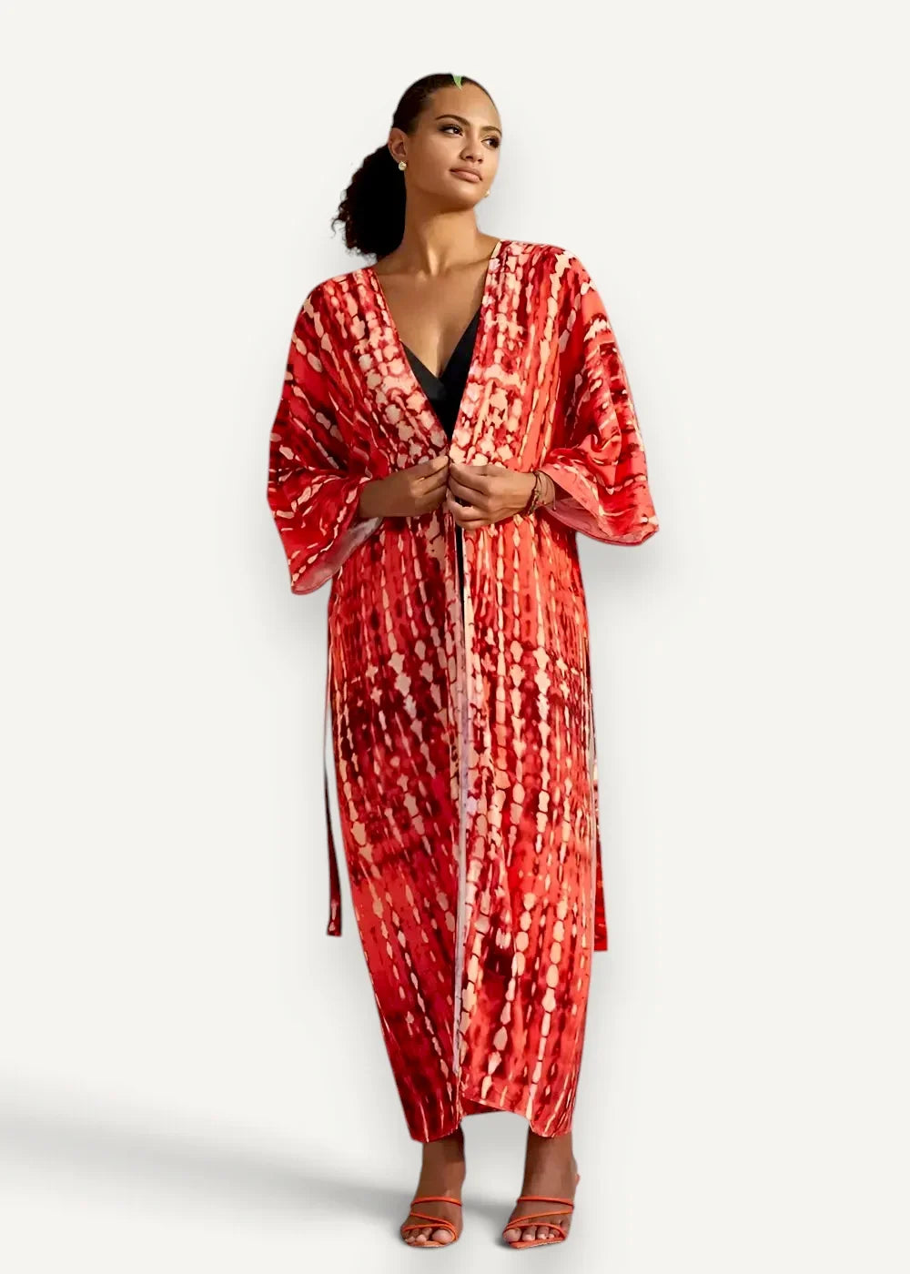 Open front kimono cover up with flowing red and white tie-dye fabric featuring a v-neckline and long sleeves