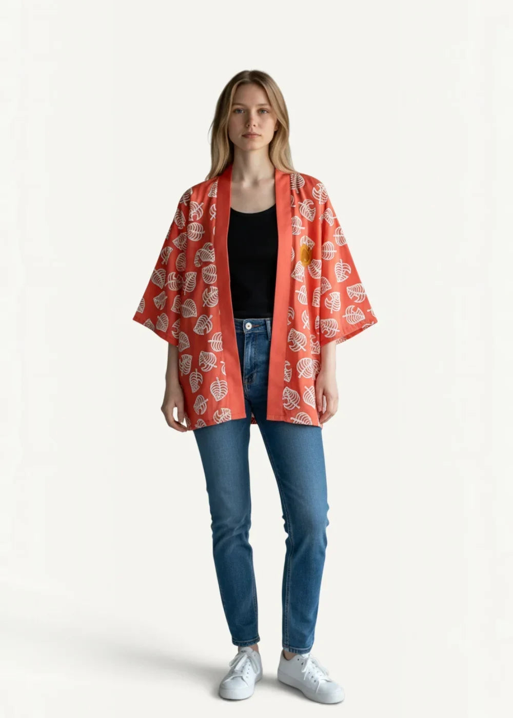 A vibrant coral orange haori kimono jacket with white leaf pattern worn over black top and blue jeans