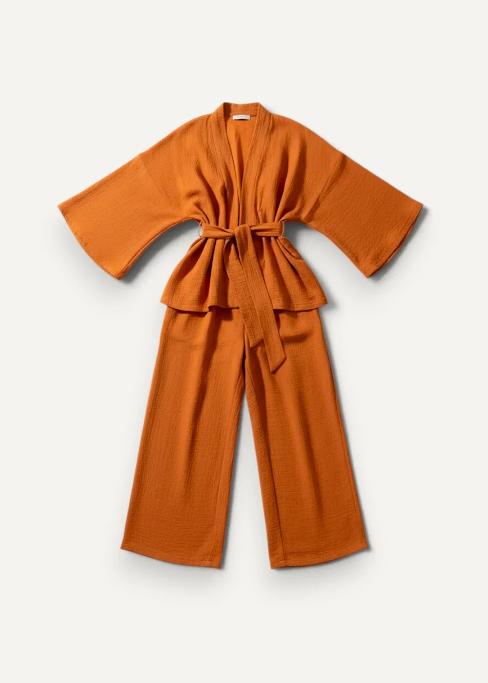 A soft rust-orange kimono pajama robe with wide sleeves and a matching belt tied at the waist