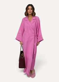 A vibrant pink kimono dress with a tailored collar wide sleeves and a matching belt tied at the waist