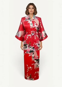 A vibrant red silk robe with a flowing floral pattern in shades of pink and green made of satin