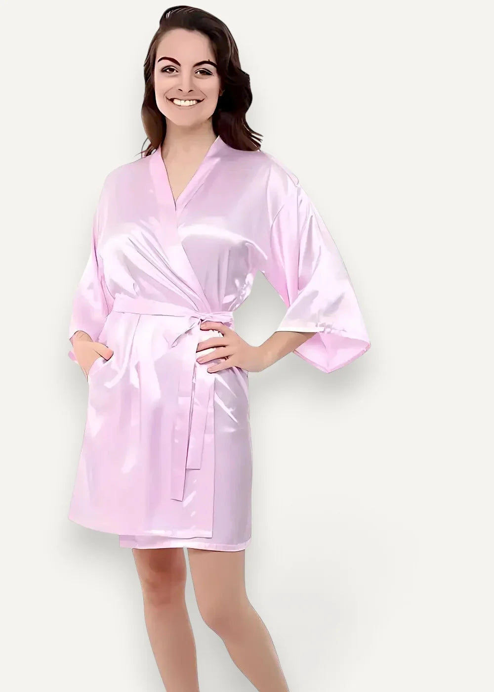 A soft pink satin robe for women with v-neckline wide sleeves and a matching belt tied at the waist