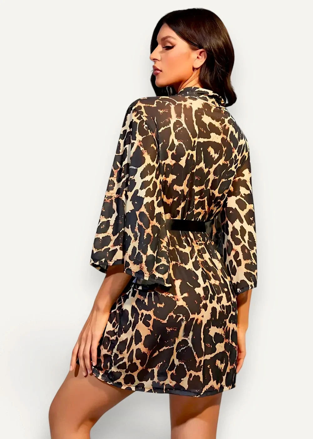 A woman wearing a short leopard-print kimono robe with three-quarter sleeves and a black belt