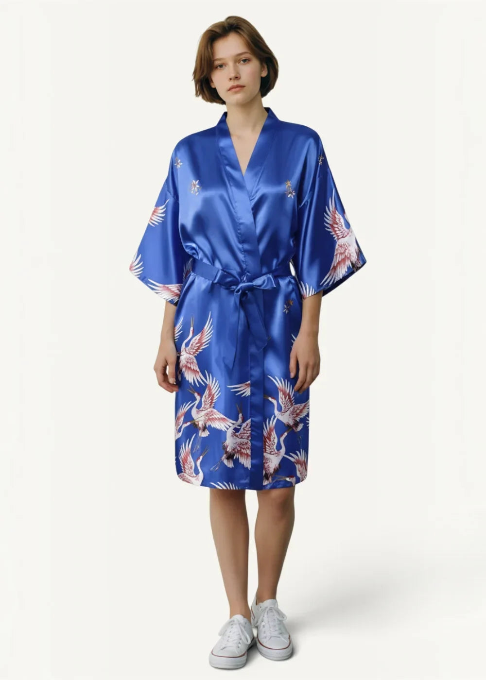 A vibrant royal blue short silk robe with a flowing white and pink crane pattern in satin material