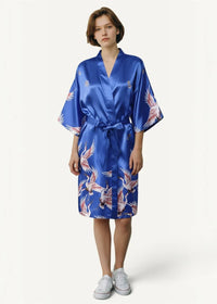 A vibrant royal blue short silk robe with a flowing white and pink crane pattern in satin material