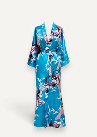 A vibrant turquoise silk bath robe with delicate pink purple and black floral and peacock patterns
