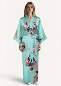 A light teal silk robe for women with a delicate peacock and pink flower print tied at the waist with sash