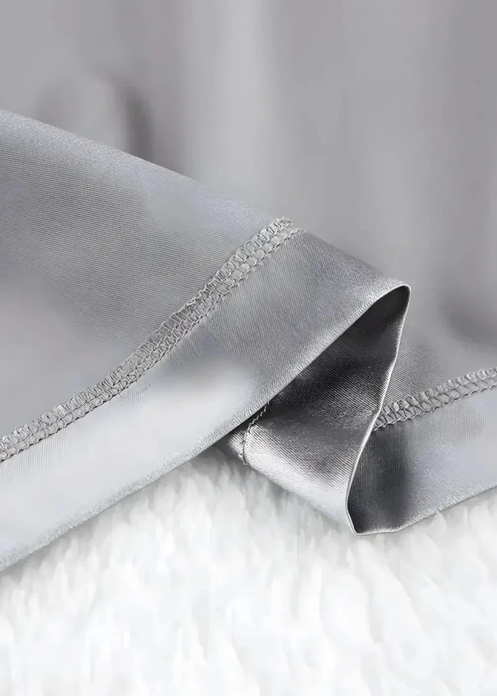 Silver silk satin robe showing smooth glossy fabric with precise stitching along the edge