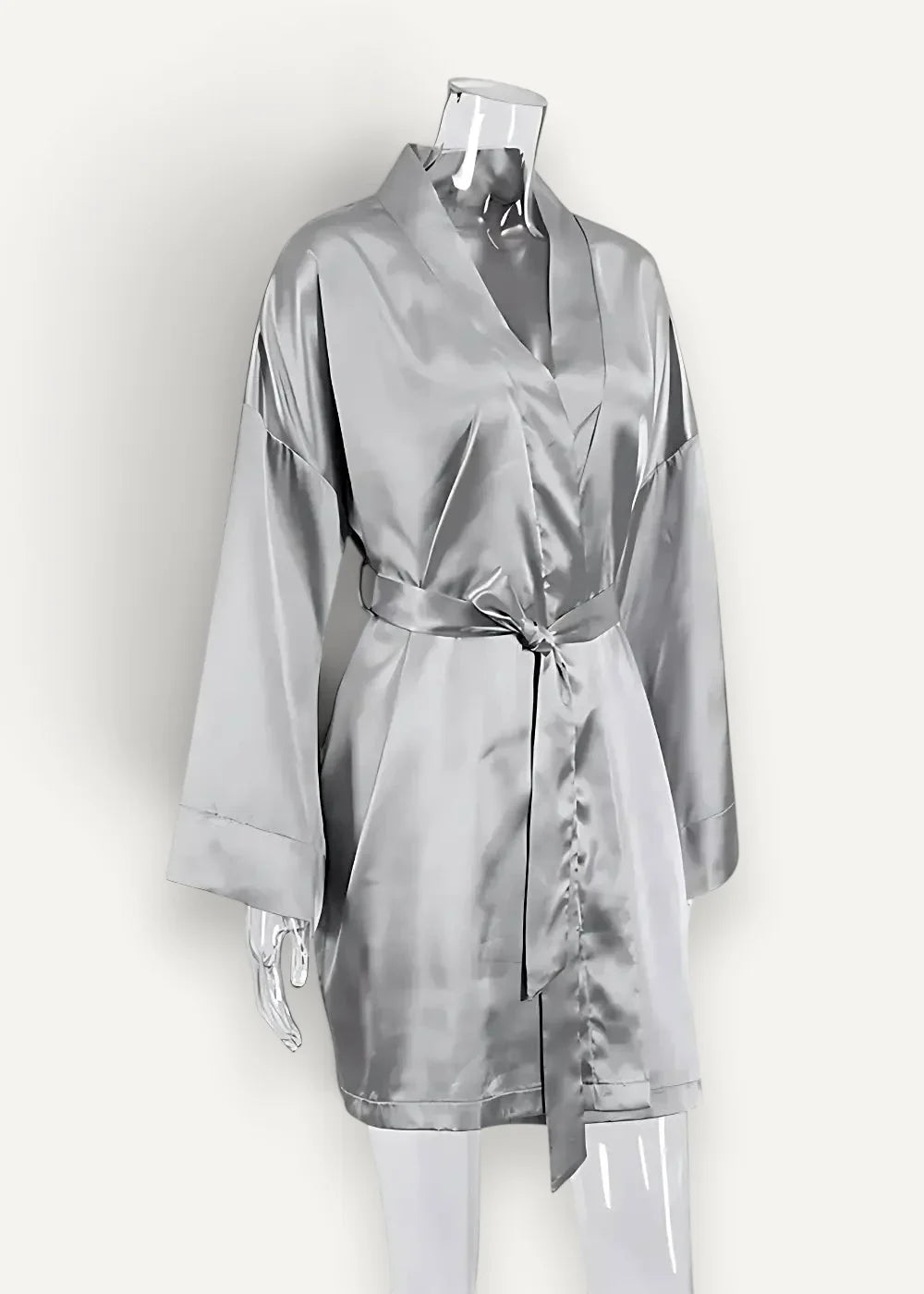 A sleek silver silk satin robe with v-neckline and matching belt tied at the waist for elegant lounging