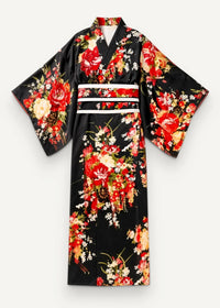 Traditional black Japanese kimono made of silk with vibrant red yellow white floral patterns and a wide white obi belt
