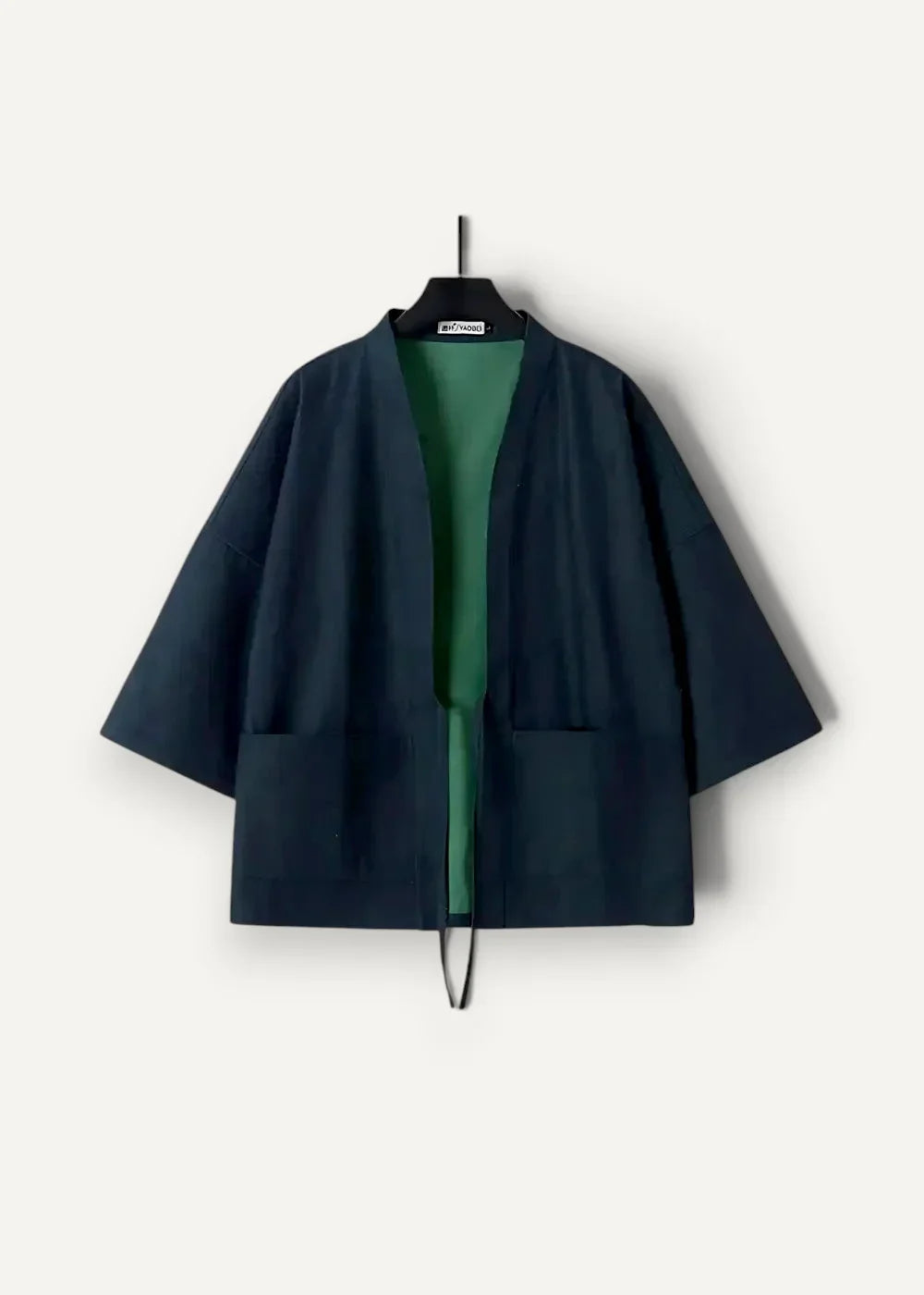 Traditional japanese kimono jacket in dark navy blue with wide sleeves and contrasting green inner lining