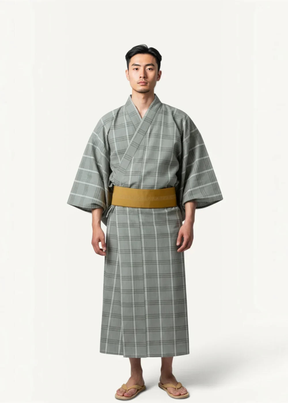 A man wearing a gray and white plaid yukata with a mustard-yellow obi belt in a traditional Japanese male kimono style