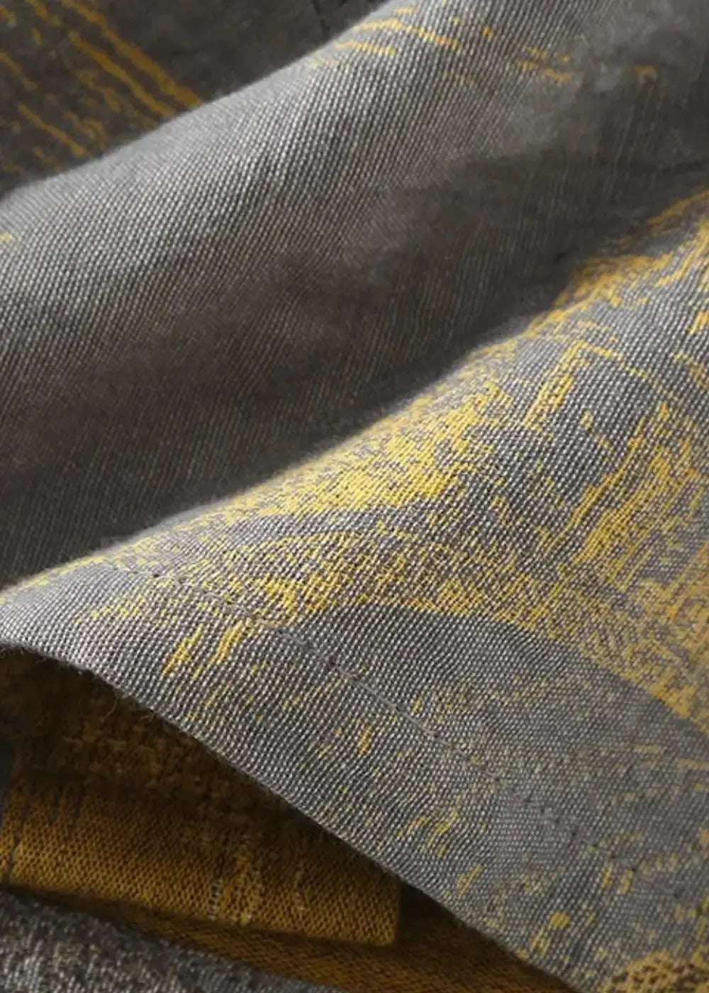 Close-up of the gray traditional kimono robe fabric with a subtle textured weave and yellow patterns