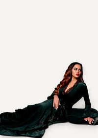 A woman wears an elegant floor-length emerald green velvet kimono robe with lace-trimmed neckline and long sleeves