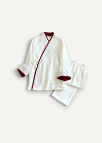 White Japanese kimono pajamas featuring a white textured fabric with red trim on collar cuffs and front placket