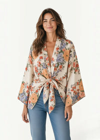 White kimono cover up featuring a flowing off-white floral fabric with wide sleeves and a tied waistband