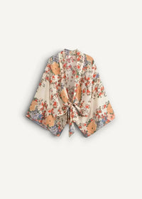 White kimono cover up flowing off-white floral fabric with vibrant orange and red blossoms and green leaves