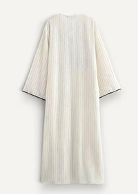 White kimono dress with flowing off-white fabric, delicate vertical stripes, and black-trimmed sleeves