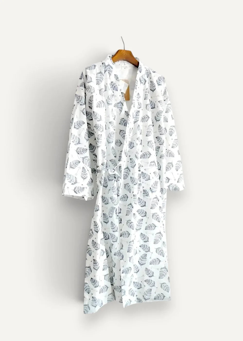 White kimono men robe in white with black leaf pattern hanging on wooden hanger made of lightweight fabric