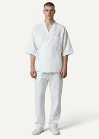Man wearing white cotton kimono pajamas with short sleeves, front pockets and matching pants