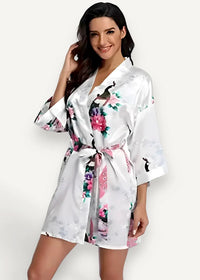 White satin robe with pink and purple floral peacock print tied at the waist for elegant loungewear