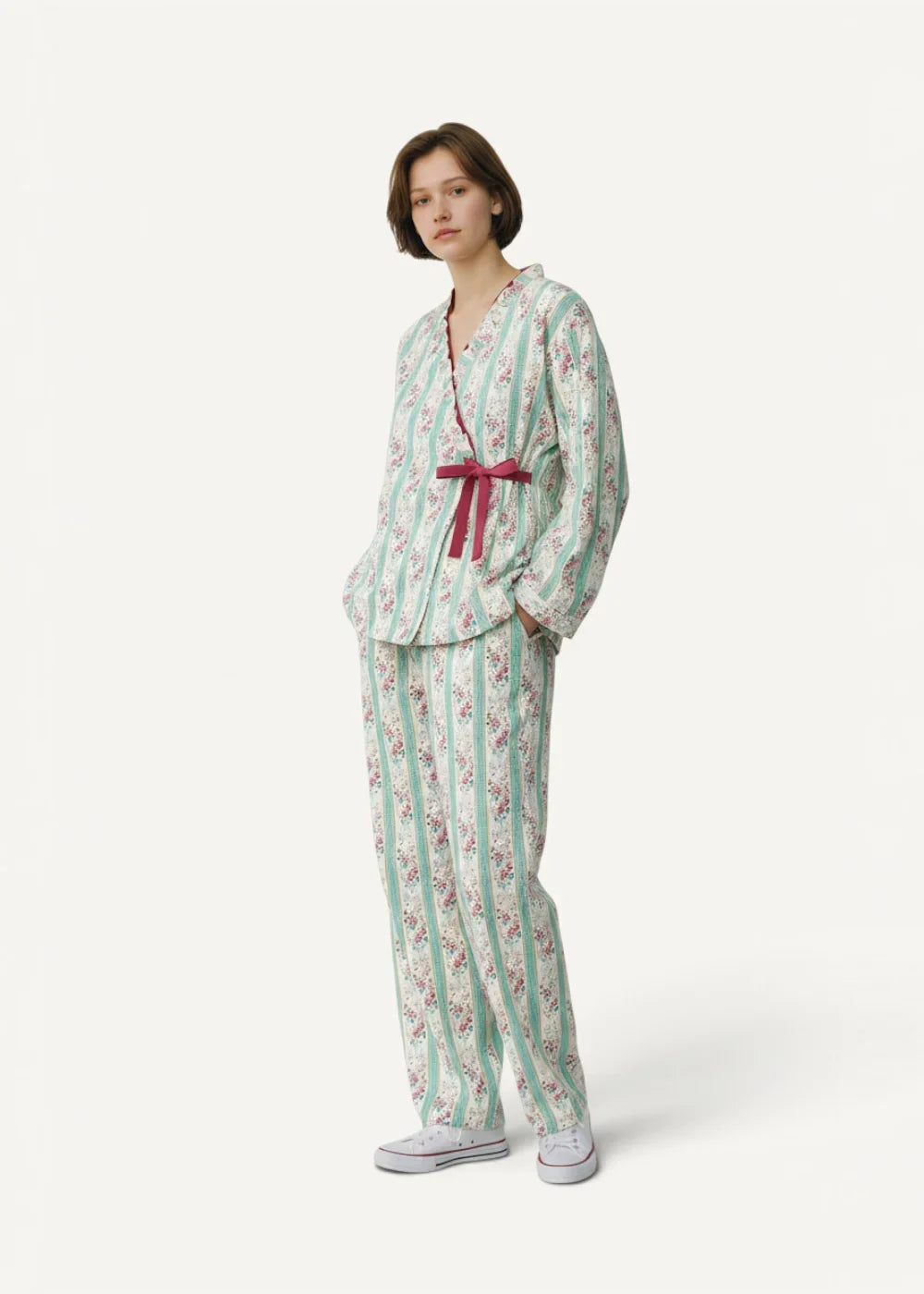 A woman wearing a women’s kimono set with mint green white stripes floral pattern and burgundy ribbon belt
